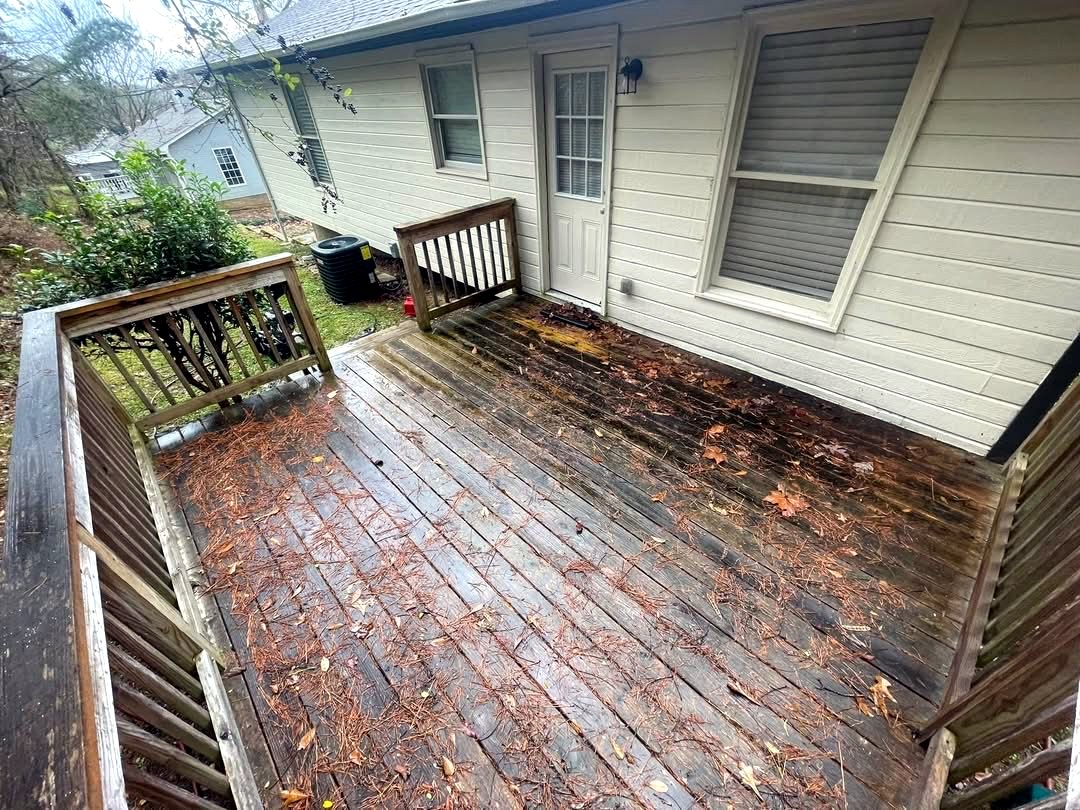 Wood deck before cleaning, gray and covered in leaves